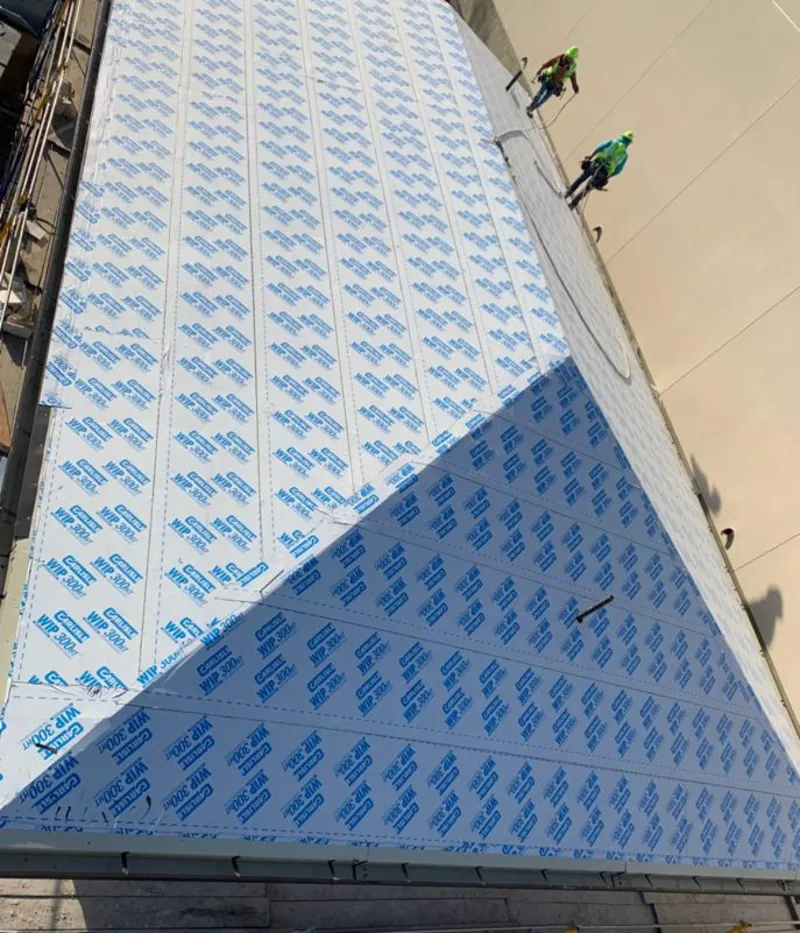 Professional roofers installing underlayment on a metal roof in Milan